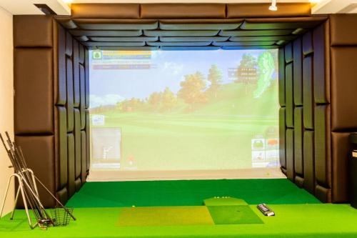 a room with a large window with a golf simulator at DIAMOND HOTEL VÂN ĐỒN in Cẩm Phả