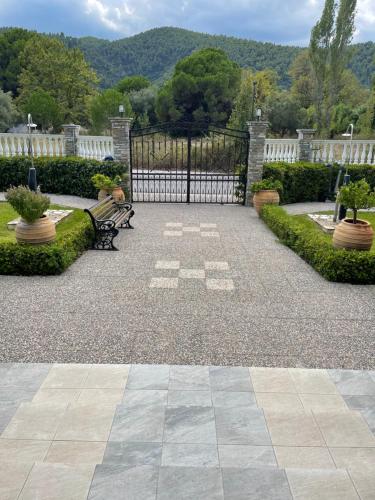 a gate in a garden with a bench and a fence at Diaporos Hotel in Vourvourou