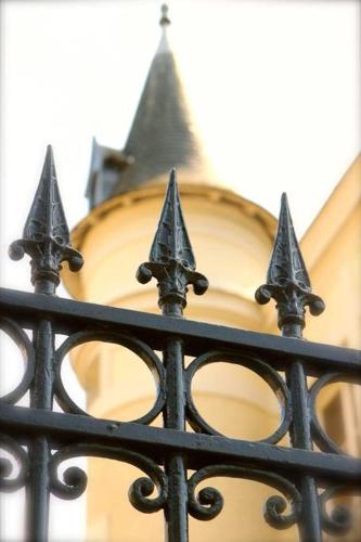 a black iron fence with a clock tower in the background at Studio à Rambouillet in Rambouillet