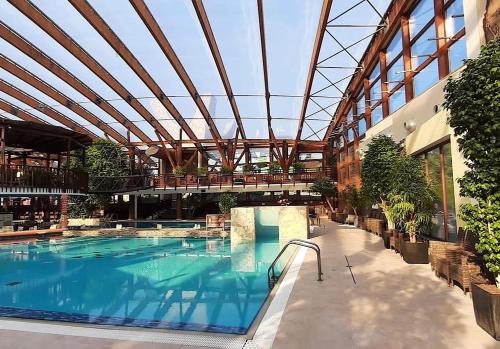 a large swimming pool in a building with a roof at Chata 107 Tatralandia Village in Liptovský Mikuláš