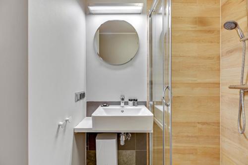 a bathroom with a sink and a shower at Apartamenty Zacisze & by Noclegi Renters in Sopot