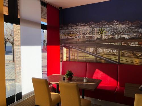 a dining room with a table and a train mural at Montana Hotel Köln-Bonn Airport in Troisdorf