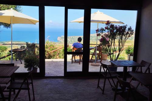 a man sitting at a table looking out of a window at B&B Tre Giummare in Scopello