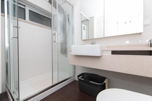 a bathroom with a glass shower and a sink at Apartamento Luz T1 Sesimbra in Sesimbra