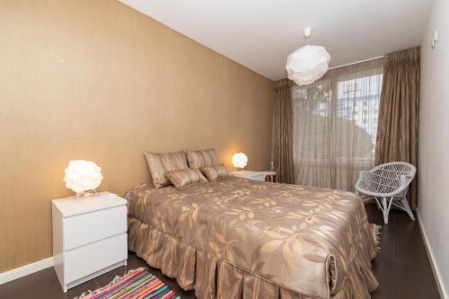 a bedroom with a large bed and a window at Apartamento Luz T1 Sesimbra in Sesimbra