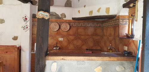 eine Küche mit einem Waschbecken und einer Holzwand in der Unterkunft Molino de Santos in Benarrabá