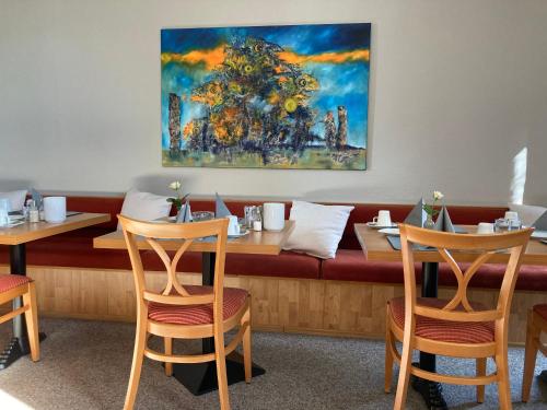a dining room with two tables and a bench at Hotel Diamant in Wedel