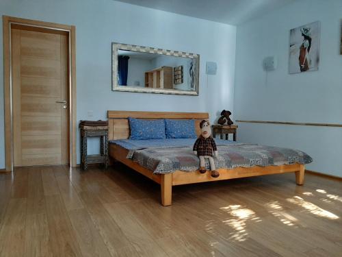 a teddy bear sitting on a bed in a bedroom at Champêtre Park View Apartments in Rīga