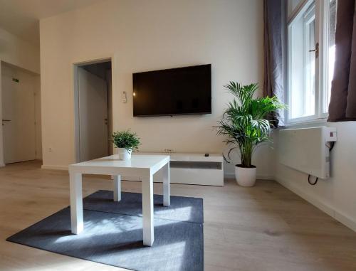 uma sala de estar com uma mesa branca e uma televisão em Meldolla em Zagreb