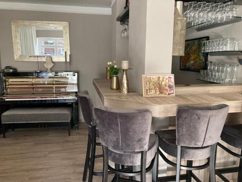 a dining room with a table and chairs and a piano at Hotel Diamant in Wedel