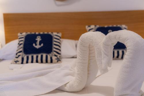 a pile of white towels on a bed at Stella Maris Marzamemi Apartments in Marzamemi