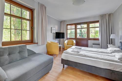 a hotel room with a bed and a couch at Apartamenty Zacisze & by Noclegi Renters in Sopot