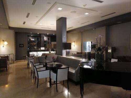 a restaurant with tables and chairs and a couch at Grand Hotel Villa Itria Congress & Spa in Viagrande