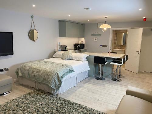 um quarto com uma cama, uma secretária e uma cozinha em The North Cove, 20m to the Sea, Modern Studio Apartment em Portrush
