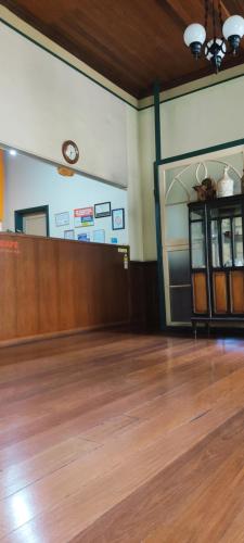 a waiting room with a wooden floor and a clock on the wall at Hotel Bandeirante in Oliveira