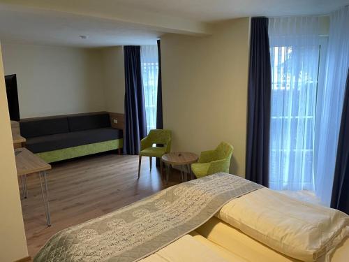 a bedroom with a bed and a couch and a table at Moselromantik Hotel Am Panoramabogen in Cochem