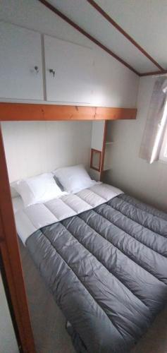 Bett in einem kleinen Zimmer mit Etagenbett in der Unterkunft Chalet mobil-home in Pénestin