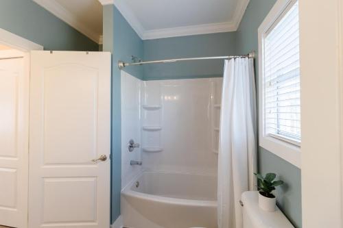 bagno con vasca bianca e doccia di Purple Parrot 19Cd By Pkrm a Pensacola