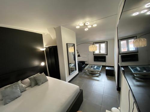 a bedroom with a white bed and a living room at Suite Apollon - Centre-ville in Saint-Étienne