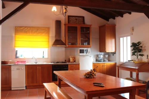 a kitchen with wooden cabinets and a wooden table at Casa da Felicidade in Pataias