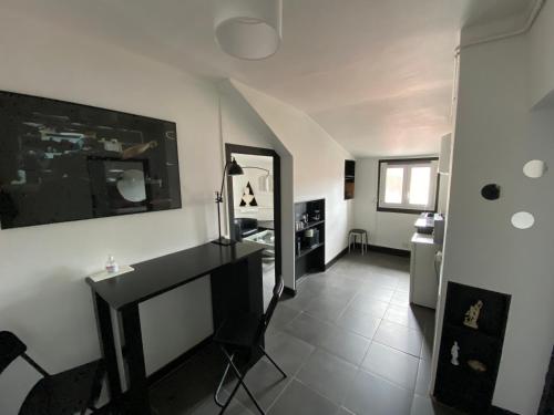 a living room with a black table and a mirror at Suite Apollon - Centre-ville in Saint-Étienne