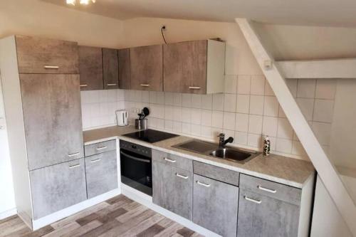 ヴィルヘルムスハーフェンにある1 ZKB DG Ferienwohnung - Direkt am Kurpark - Zentrale Lageのキッチン(ステンレス製のキャビネット、シンク付)