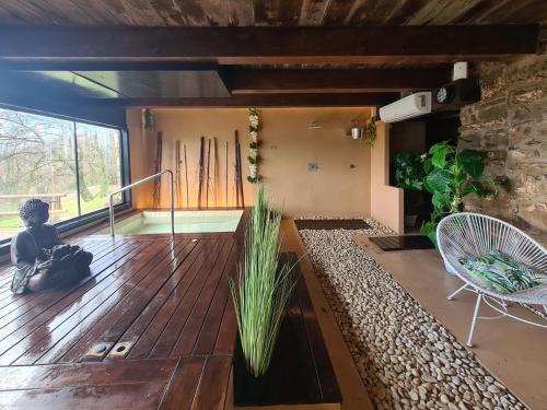 una camera con terrazza in legno con sedia e finestra di Hotel Rural & Spa Mas Prat a Vall de Bianya