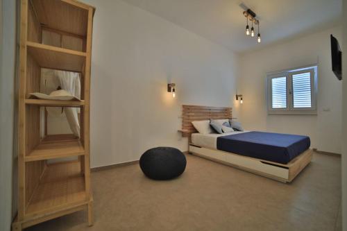 um quarto com uma cama e uma estante de livros em GIARO' APARTMENTS em Porto Cesareo