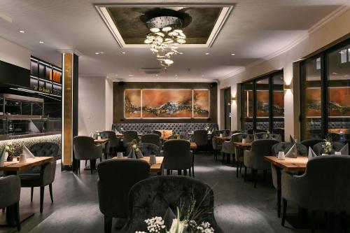 a dining room with tables and chairs and a chandelier at Boutique Hotel Canel in Würzburg