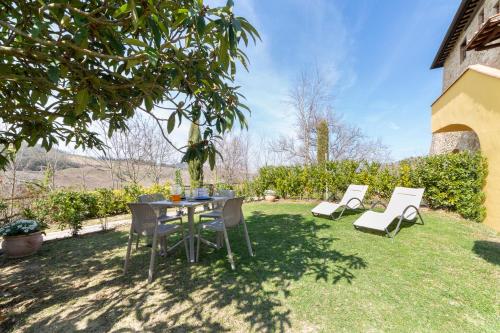 a table and chairs sitting in the grass at Torre di Polvereto in Montespertoli