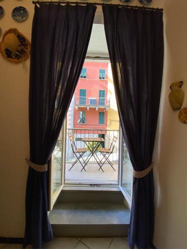 una ventana con cortinas negras y una mesa en el balcón en Il poggiolo di Rio, en Riomaggiore