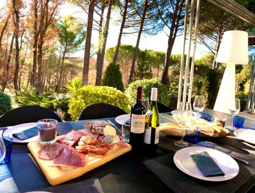 een tafel met een bord vlees en twee flessen wijn bij Provence mon amour in La Tour-dʼAigues