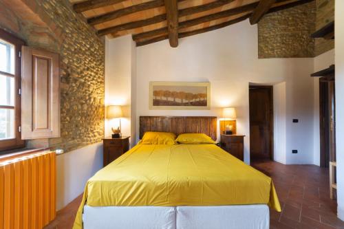 a bedroom with a bed with a yellow bedspread at Torre di Polvereto in Montespertoli