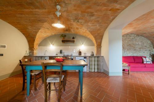a kitchen and dining room with a table and a couch at Torre di Polvereto in Montespertoli