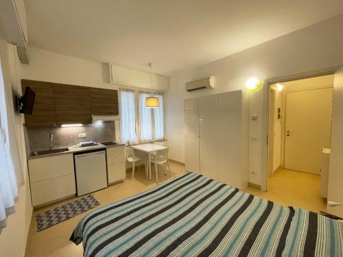 a small room with a bed and a kitchen at Residence Glicini in Finale Ligure