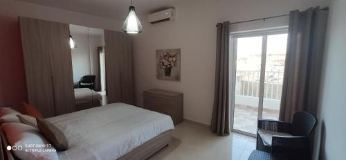 una camera con letto e porta scorrevole in vetro di Searenity a Marsaxlokk