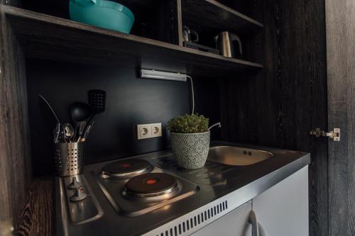 a small kitchen with a stove and a sink at Hotel Bloemfontein in Borkum