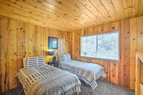 2 camas en una cabaña de madera con ventana en Mountain Chalet in Big Bear City, 5 Mi to Lake!, en Big Bear City
