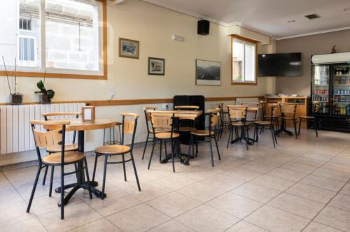 ein Esszimmer mit Tischen und Stühlen in einem Restaurant in der Unterkunft A Pousa Pensión rural (Camino de Santiago Sanabrés) in Armariz