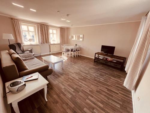 un salon avec un canapé et une table dans l'établissement Ferienwohnung Strandeck - Inklusive Strandkorb in den Sommermonaten, à Göhren