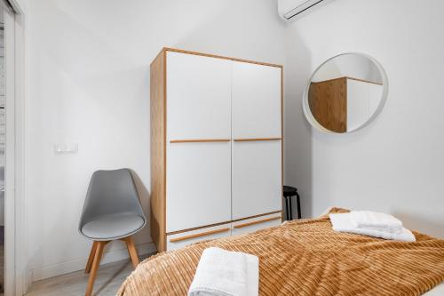 a bedroom with a mirror and a bed and a chair at Minty Stay - Hortaleza Studio in Madrid
