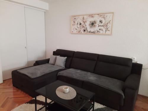 a living room with a black couch and a table at Apartments Rose Loboja in Makarska