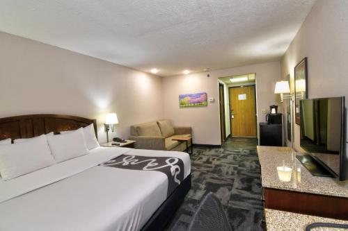 a hotel room with a bed and a couch at La Quinta by Wyndham Springfield South in Springfield