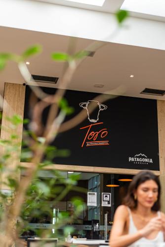 a woman walking past a sign in a store at Jade Hotel Brasília in Brasilia