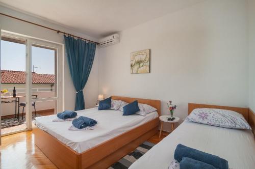 2 Einzelbetten in einem Zimmer mit Fenster in der Unterkunft APARTMAN NEVEN in Podgora