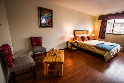 a bedroom with a bed and a table and a chair at ISKAY BOUTIQUE HOSTEL in La Paz