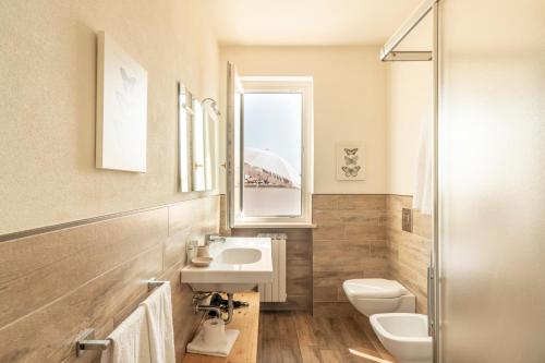 a bathroom with a sink and a toilet and a window at Residence Bianca in Sirmione
