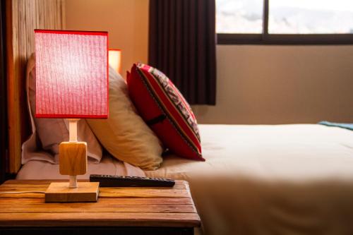 a lamp on a table next to a bed at ISKAY BOUTIQUE HOSTEL in La Paz
