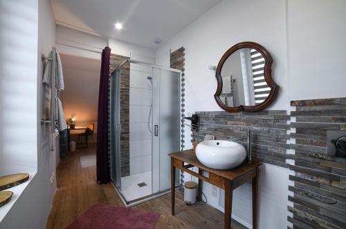 a bathroom with a sink and a mirror at La Maison Fleur de Frangipanier in Saint-Genix-sur-Guiers