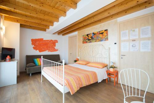 a bedroom with a white bed and a couch at B&B Del Centro in Clusone